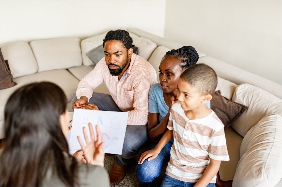 A family speaking with a support professional during a consultation